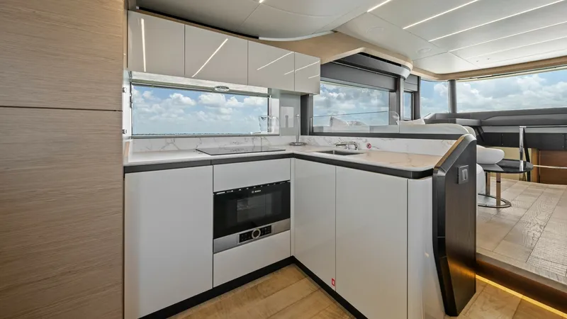 Slide: The Image of Modern Galley with Ocean Views The sleek and modern galley of the 2026 Absolute Navetta 58 offers stunning ocean views through expansive windows. Featuring high-end appliances and minimalist cabinetry, this space is both functional and stylish. The open layout flows seamlessly into the - 7018616