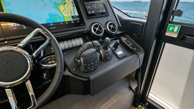Slide: The Image of Helm Station with Navigation Displays The helm station of the Absolute Navetta 58 offers cutting-edge navigation technology with dual digital displays, providing comprehensive control and monitoring. The sleek carbon-fiber finish enhances the modern aesthetic, while ergonomic controls ensure - 7018640