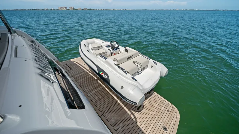 Slide: The Image of Extended Swim Platform with Tender The Absolute Navetta 58's spacious swim platform extends gracefully over the water, offering easy access and storage for the tender. The teak decking adds a touch of elegance and durability, ideal for waterside relaxation or launching water activities. Th - 7018682