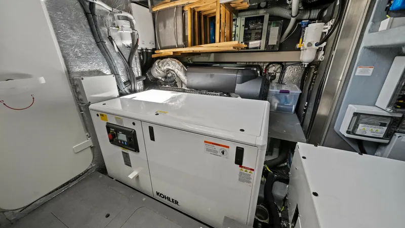 Slide: The Image of Engine Room with Kohler Generator The engine room of the 2026 Absolute Navetta 58 showcases a robust Kohler generator, ensuring reliable power supply for extended voyages. The space is meticulously organized, featuring high-quality insulation and accessible maintenance points. Modern engi - 7018677
