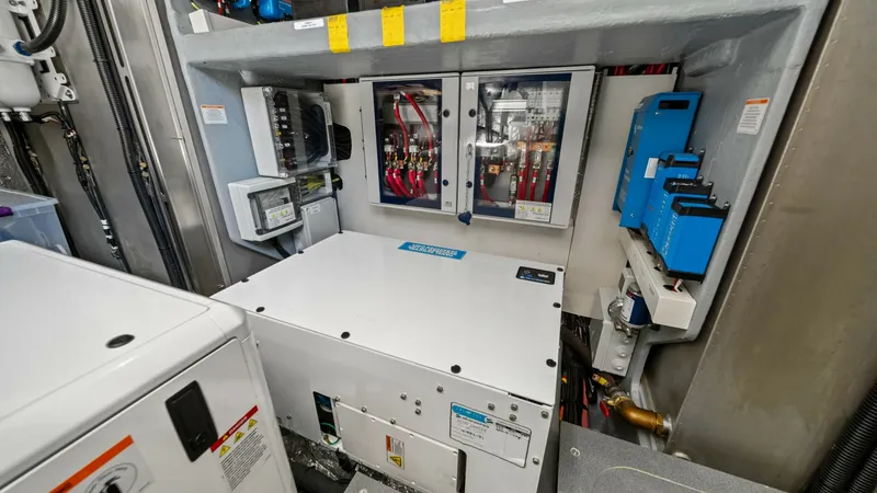 Slide: The Image of Engine Room Electrical Systems The engine room of the Absolute Navetta 58 showcases advanced electrical systems, featuring neatly organized wiring and high-quality components. This setup includes a robust power management system, ensuring efficient energy distribution throughout the ve - 7018675