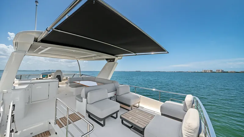 Slide: The Image of Flybridge Lounge Area with Sunshade The flybridge on the Absolute Navetta 58 offers a luxurious lounge area complete with plush seating and sleek, modern design. A retractable sunshade provides comfort and protection, making it perfect for entertaining or relaxing while enjoying panoramic o - 7018666