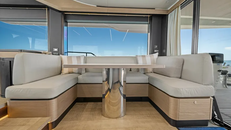 Slide: The Image of Spacious Interior Dining Area The interior dining area of the 2026 Absolute Navetta 58 features plush, wrap-around seating and a sleek, modern table with a polished metal base. Large windows provide panoramic views, enhancing the sense of space and connection to the outdoors. The ligh - 7018620