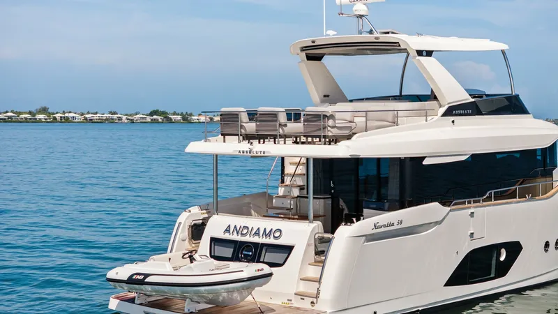 Slide: The Image of Aft Deck with Tender The aft deck of the Absolute Navetta 58 features a spacious platform with easy access to the water, perfect for launching the included tender. The sleek design of the ANDIAMO is complemented by modern seating arrangements, offering both comfort and style. - 7018685