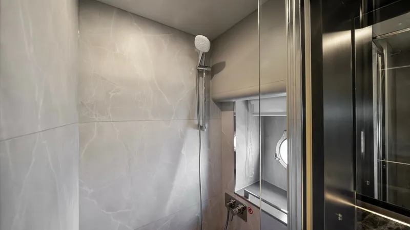 Slide: The Image of Luxurious Ensuite Shower The ensuite shower on the Absolute Navetta 58 boasts elegant marble-like tiles that create a sophisticated ambiance. A sleek, modern showerhead and a large window provide both functionality and natural light, enhancing the spa-like experience. The high-qu - 7018625