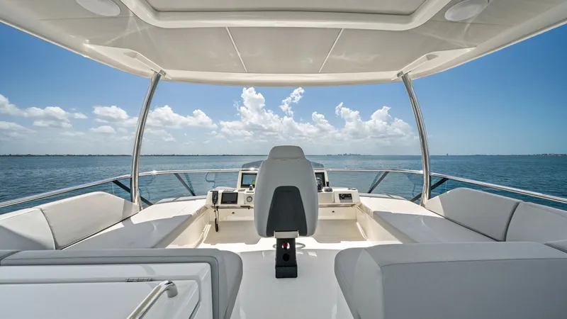 Slide: The Image of Flybridge Helm with Ocean View The flybridge of the Absolute Navetta 58 offers a commanding helm station with panoramic ocean views. The area features plush seating, perfect for leisurely cruising or entertaining guests under the open sky. The sleek design and advanced navigation equip - 7018659