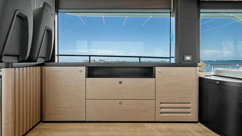 Slide: The Image of Modern Interior with Ocean View The interior of the Absolute Navetta 58 showcases sleek cabinetry with a natural wood finish, enhancing the modern aesthetic. Large windows provide an uninterrupted view of the ocean, flooding the space with natural light. The clean lines and high-quality - 7018623