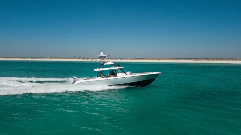 Slide: The Image of Side View Cruising on Open Water The 2023 Everglades 455 Center Console, 'Cash Cow,' showcases its sleek profile while cruising effortlessly on clear blue waters. This side view highlights the vessel's streamlined hull and spacious deck, perfect for both leisure and sport. The pristine d - 7095099
