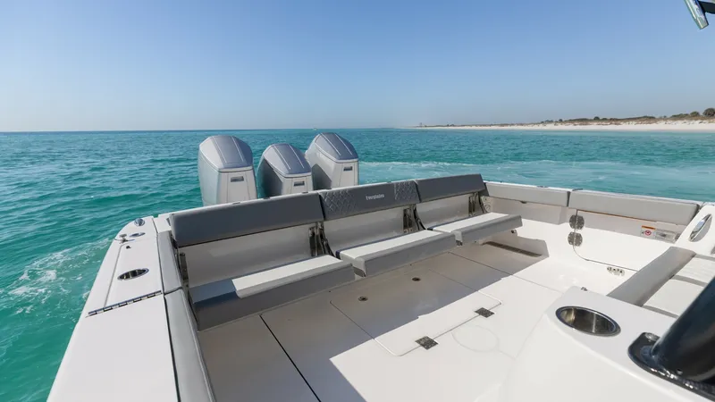 Slide: The Image of Spacious Aft Deck with Seating The aft deck of the 2023 Everglades 455 Center Console features ample seating, perfect for relaxation and socializing. The clean, modern design offers convenient access to the triple outboard engines, emphasizing both style and functionality. Surrounded b - 7095065