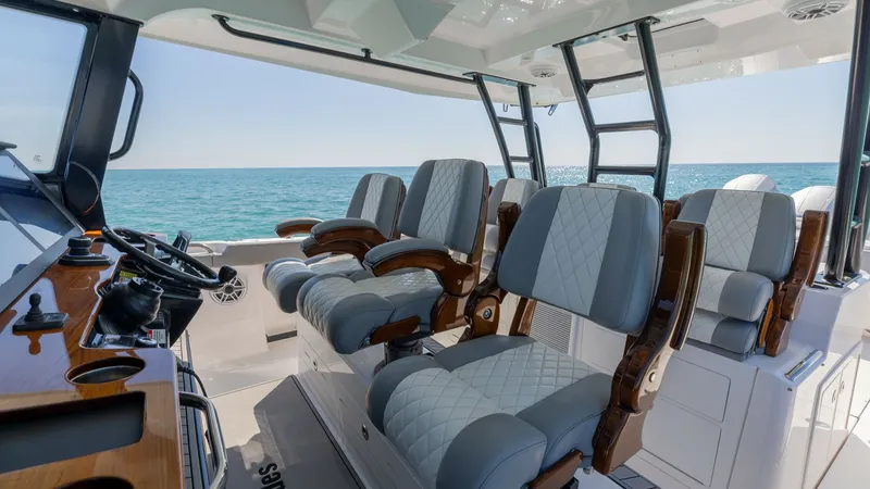 Slide: The Image of Helm Seating Area with Ocean View The Everglades 455 Center Console features a luxurious helm seating area with plush, diamond-stitched upholstery and elegant wooden armrests. Designed for comfort and style, the seating arrangement offers unobstructed views of the ocean, enhancing the boa - 7095071