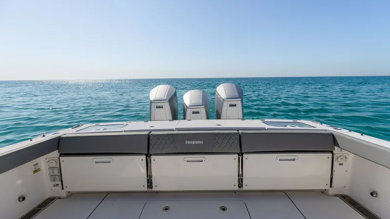 Slide: The Image of Triple Outboard Engine Transom View This image showcases the powerful triple outboard engines on the Everglades 455 Center Console, providing robust performance and speed. The spacious aft deck features sleek, integrated storage options, enhancing functionality for fishing and leisure. The - 7095062