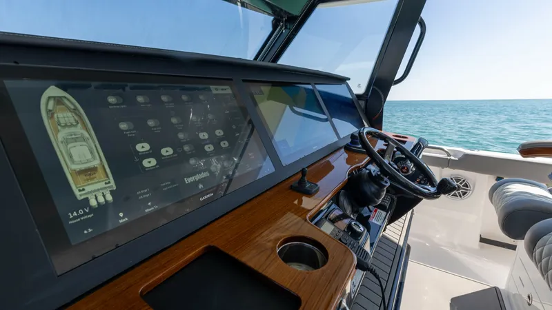 Slide: The Image of Helm Station with Advanced Electronics The helm station of the 2023 Everglades 455 Center Console 'Cash Cow' features state-of-the-art electronics, including a large, multifunctional display for easy navigation and system management. The sleek, wood-accented console complements the ergonomic s - 7095068