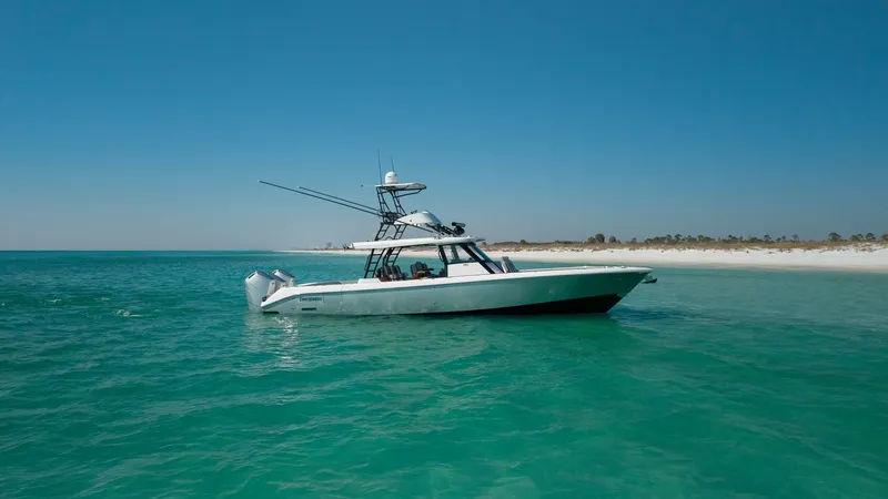 Slide: The Image of Side Profile on Open Water The 2023 Everglades 455 Center Console, known as 'Cash Cow', is showcased in pristine turquoise waters. Its sleek profile highlights the robust, aerodynamic design and powerful outboard motors, ideal for swift oceanic adventures. The vessel's modern hardt - 7095091