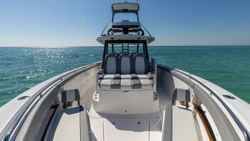 Slide: The Image of Forward Seating and Helm Station This image showcases the forward seating area and helm station of the 2023 Everglades 455 Center Console, 'Cash Cow.' The spacious bow features plush, diamond-stitched seating, perfect for relaxation while cruising. The helm is equipped with advanced navi - 7095080