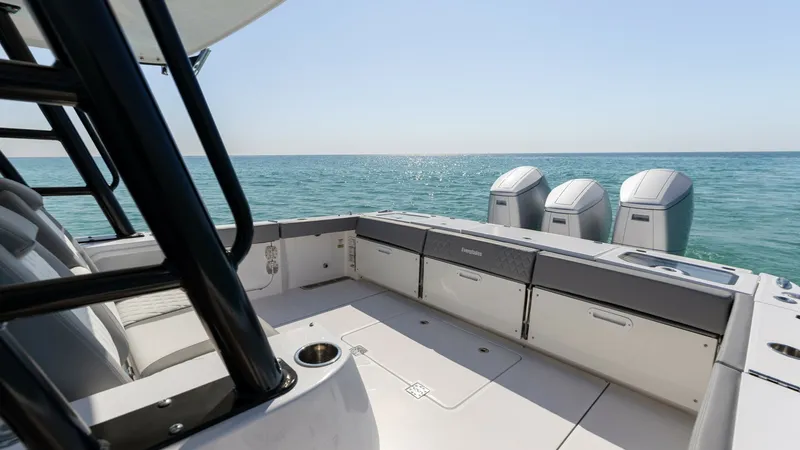 Slide: The Image of Spacious Aft Deck with Triple Engines The aft deck of the 2023 Everglades 455 Center Console offers both functionality and style, featuring ample seating and storage options. Highlighted by its powerful triple-engine setup, this area is designed for both relaxation and performance while cruis - 7095063