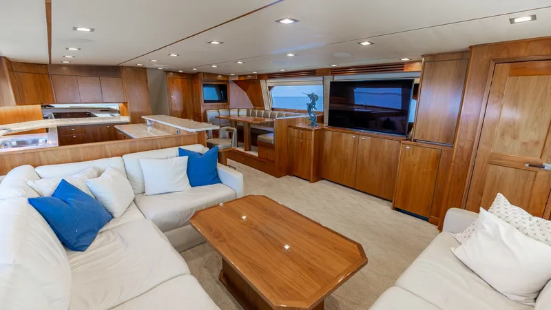 Slide: The Image of Spacious Interior Salon with Galley The interior salon of the 2016 Viking 80 Convertible offers a luxurious and inviting space with plush seating and elegant wood finishes. The open layout seamlessly connects to a modern galley, featuring state-of-the-art appliances and a sleek design. Larg - 7150164