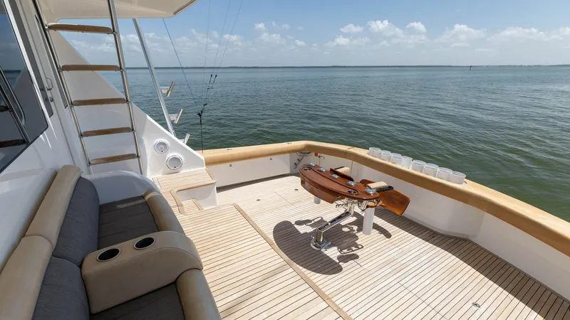 Slide: The Image of Spacious Aft Deck with Fishing Chair This inviting aft deck on the 2016 Viking 80 Convertible features elegant teak flooring and a professional-grade fishing chair, perfect for angling enthusiasts. The plush seating provides comfort while enjoying panoramic ocean views. Its open layout and t - 7150200