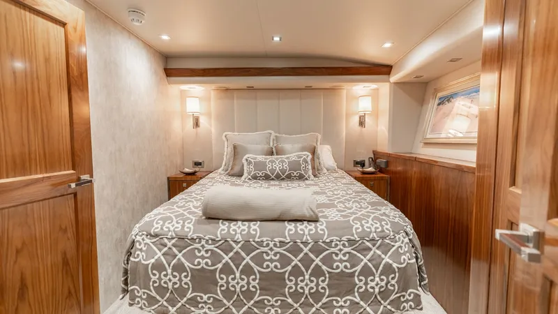 Slide: The Image of Luxurious Master Stateroom The master stateroom of the 2016 Viking 80 Convertible exudes elegance with its rich wood finishes and plush bedding. Soft ambient lighting enhances the serene atmosphere, while the spacious layout provides ample comfort. A large window invites natural li - 7150174