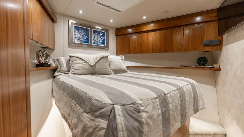 Slide: The Image of Guest Stateroom with Double Berth This inviting guest stateroom features a comfortable double berth adorned with plush linens. Rich wood cabinetry offers ample storage, complementing the warm, ambient lighting throughout. Elegant artwork and soft textures create a cozy and sophisticated r - 7150186