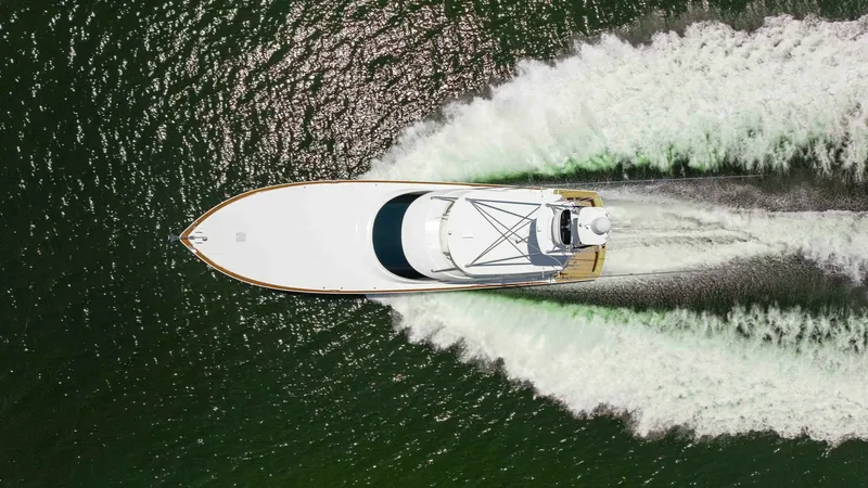 Slide: The Image of Aerial View of Viking 80 Convertible This overhead shot captures the sleek design of the 2016 Viking 80 Convertible as it slices through the water. The vessel's streamlined hull and expansive deck are highlighted, showcasing its superior craftsmanship and performance. The wake pattern illust - 7150224