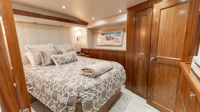 Slide: The Image of Elegant Master Stateroom Interior This luxurious master stateroom on the 2016 Viking 80 Convertible features rich wood finishes and plush bedding, creating a warm and inviting atmosphere. Recessed lighting and tasteful decor enhance the sense of space and comfort. Ample storage is integra - 7150175