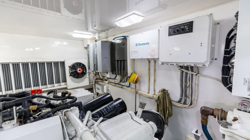 Slide: The Image of Engine Room with Electrical Panels This image showcases the well-organized engine room of the 2016 Viking 80 Convertible. Featuring neatly arranged electrical panels and wiring, the space is designed for optimal functionality and ease of access. The bright lighting and clean layout highlig - 7150213
