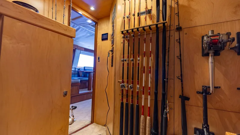 Slide: The Image of Fishing Rod Storage Area The image showcases a dedicated fishing rod storage area on the 2016 Viking 80 Convertible. The wooden cabinetry is custom-designed to securely hold multiple rods, ensuring they are easily accessible and well-organized. This functional space is a must for - 7150171
