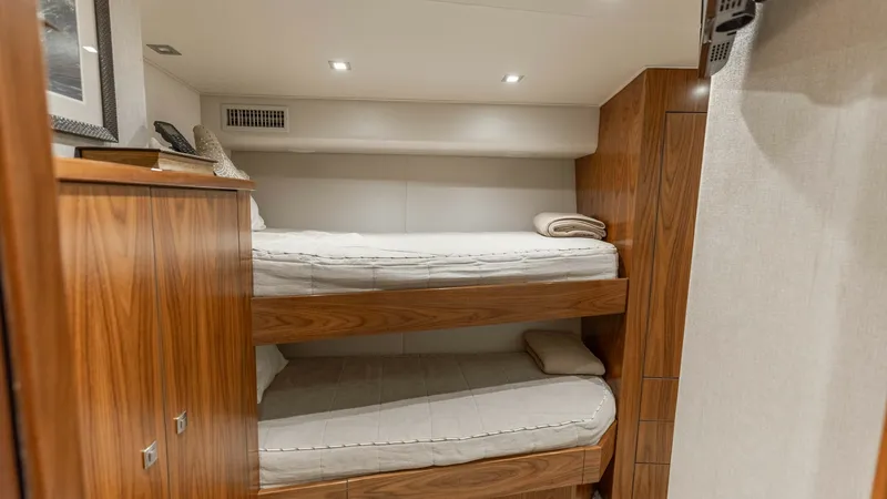 Slide: The Image of Guest Stateroom with Bunk Beds This cozy guest stateroom features well-appointed bunk beds with plush bedding, providing a comfortable retreat for guests. The warm wood finishes and ample storage add a touch of elegance and functionality. Recessed lighting enhances the welcoming ambian - 7150193