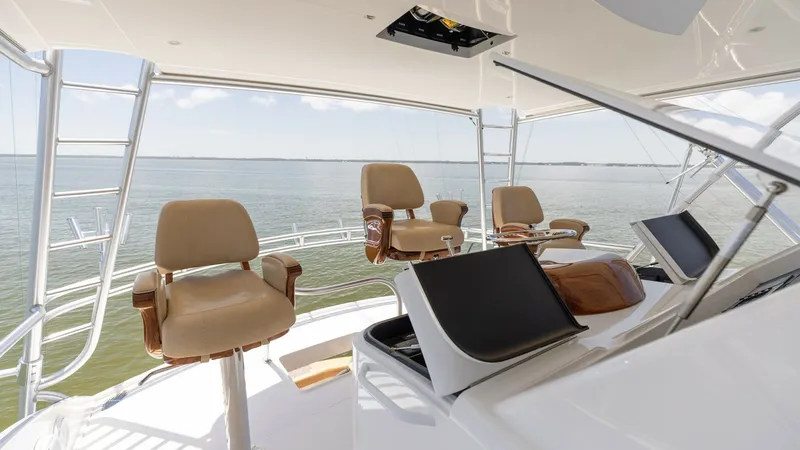 Slide: The Image of Flybridge Helm Station with Seating The Viking 80 Convertible's flybridge offers a commanding view with three luxurious helm chairs. The helm station is equipped with state-of-the-art navigation displays, ensuring a seamless sailing experience. The open layout and ample seating make it an i - 7150203