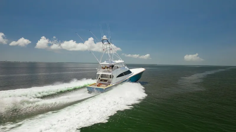 Slide: The Image of Aerial View of Viking 80 Underway This dynamic aerial shot captures the Viking 80 Convertible cutting through the water with impressive speed and agility. The vessel's sleek lines and robust design are highlighted against the expansive ocean backdrop. The flybridge and outriggers are prom - 7150222