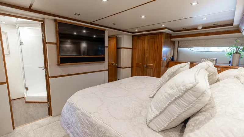 Slide: The Image of Luxurious Master Stateroom The master stateroom aboard the 2016 Viking 80 Convertible offers a plush and inviting space with a large, comfortable bed adorned with premium linens. Rich wood finishes add warmth, complemented by recessed lighting that creates an ambient atmosphere. Th - 7150182