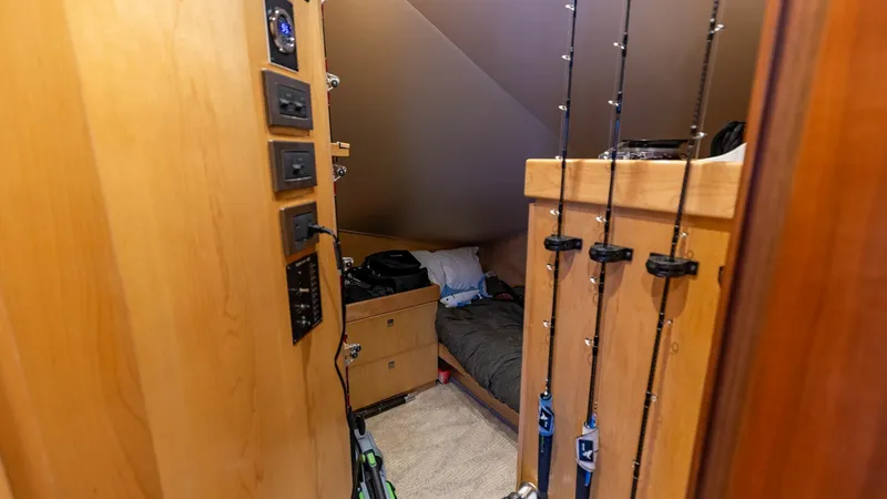 Slide: The Image of Tackle Storage and Utility Room This cozy utility space on the 2016 Viking 80 Convertible features dedicated rod storage, ideal for avid fishermen. The room includes built-in cabinetry and control panels for easy access to essential equipment. The compact layout maximizes functionality - 7150172