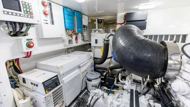 Slide: The Image of Engine Room with Generator Systems The engine room of the 2016 Viking 80 Convertible showcases advanced generator systems and mechanical components. The space is meticulously organized with control panels and essential equipment, ensuring efficient operation and easy access for maintenance - 7150212
