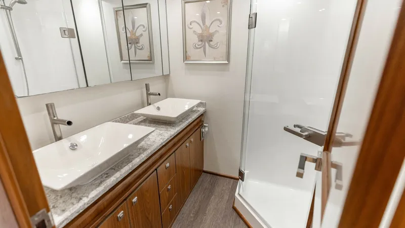 Slide: The Image of Elegant Ensuite Bathroom This luxurious ensuite bathroom on the 2016 Viking 80 Convertible features dual rectangular sinks set in a sleek granite countertop. The modern fixtures and ample storage space enhance functionality, while the glass-enclosed shower adds a touch of sophist - 7150183