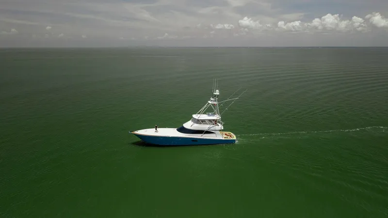 Slide: The Image of Aerial View of Viking 80 Convertible This image captures the sleek profile of the 2016 Viking 80 Convertible gliding through open waters. The expansive deck and distinctive tower are prominent, showcasing its sportfishing capabilities and luxurious design. The vessel's elegant silhouette aga - 7150218