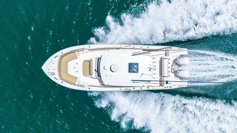 Slide: The Image of Aerial View of Pursuit 328 This striking aerial shot showcases the sleek design of the 2019 Pursuit 328. The vessel's spacious bow seating area invites relaxation, while the dual outboard engines deliver powerful performance. The clean lines and elegant finishes make this yacht a s - 7095054
