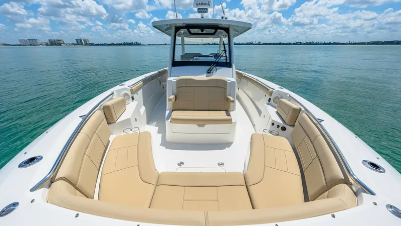 Slide: The Image of Spacious Bow Seating Area The Pursuit 328's bow offers a luxurious seating area with plush, tan upholstery, perfect for relaxation and enjoying scenic views. The wraparound seating configuration maximizes space and comfort, while stainless steel fixtures add a touch of elegance. T - 7095010