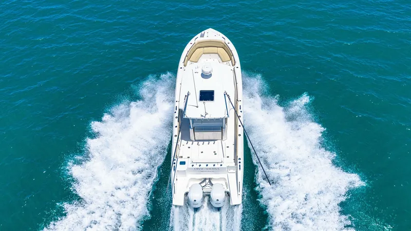 Slide: The Image of Aerial View of Aft Deck and Engines The Pursuit 328 Orcabessa showcases its powerful twin engines from an aerial perspective, cutting through the water with ease. The spacious aft deck offers ample seating for relaxation, while the clean, modern lines emphasize the vessel's sleek design. Id - 7095055