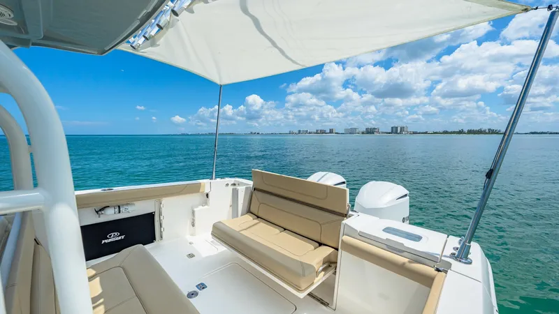 Slide: The Image of Spacious Aft Deck with Seating The aft deck of the 2019 Pursuit 328, Orcabessa, offers ample seating with plush, beige cushions perfect for relaxation. A retractable sunshade provides comfort and protection from the sun, enhancing the outdoor experience. The area is designed for both l - 7095025