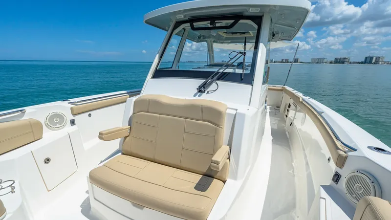 Slide: The Image of Bow Seating Area The Pursuit 328's bow features plush, cream-colored seating with armrests, offering comfort and relaxation while underway. The sleek design and ample space make it ideal for social gatherings or enjoying panoramic ocean views. High-quality materials and a - 7095042