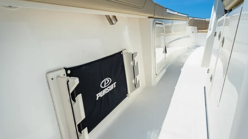 Slide: The Image of Starboard Walkway with Storage This image showcases the spacious starboard walkway of the 2019 Pursuit 328. Notable features include the integrated storage compartments, perfect for securing gear or personal items while underway. The sleek design and high-quality finishes provide both - 7095035