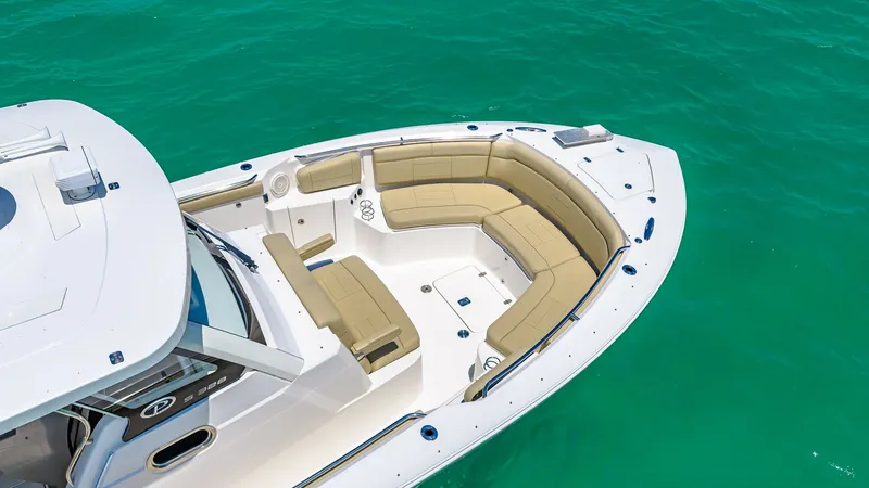 Slide: The Image of Spacious Bow Seating Area The Pursuit 328's bow features a luxurious and spacious seating area, perfect for relaxation and socializing. The plush, wrap-around cushions provide comfort and style, while the integrated cup holders add convenience. Surrounded by the vibrant turquoise - 7095015