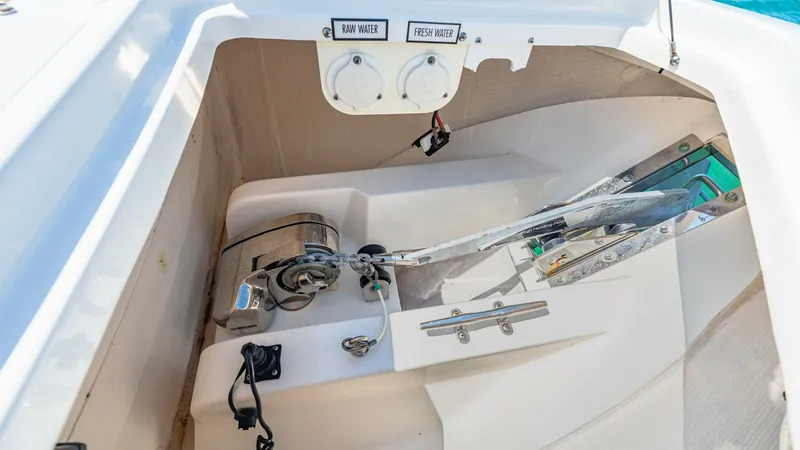 Slide: The Image of Anchor Locker with Windlass System The image showcases the anchor locker of the 2019 Pursuit 328, featuring a robust windlass system for effortless anchor management. The compartment is neatly organized, with designated spaces for raw and fresh water access, ensuring convenience and functi - 7095044