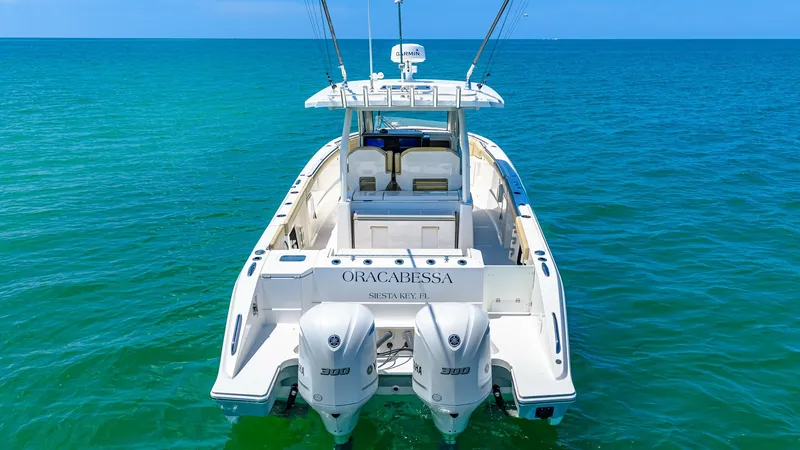 Slide: The Image of Aft Deck with Twin Engines The 2019 Pursuit 328 Orcabessa showcases a sleek aft deck equipped with powerful twin engines, perfect for smooth cruising. The spacious deck layout offers ample room for fishing or lounging, complemented by an inviting seating area under a sturdy T-top. - 7095023