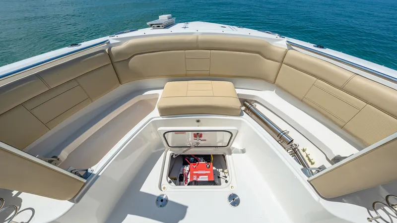 Slide: The Image of Spacious Bow Seating Area This image showcases the expansive bow seating area of the 2019 Pursuit 328, featuring plush, cream-colored cushions for comfort. The area is designed for relaxation and socializing, with ample storage compartments seamlessly integrated beneath the seats. - 7095043