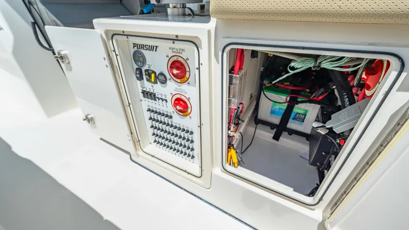 Slide: The Image of Electrical Control Panel and Storage Compartment This image showcases the electrical control panel and an adjacent storage compartment on the 2019 Pursuit 328. The panel is neatly organized with accessible switches and indicators, ensuring easy operation and maintenance. The storage area is conveniently - 7095045