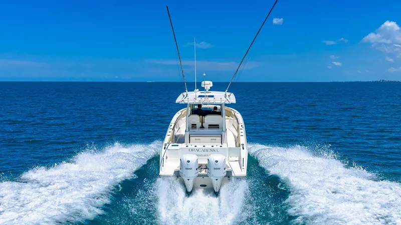 Slide: The Image of Aft View in Motion on Open Water The Pursuit 328 'Orcabessa' is captured from the aft, showcasing its powerful dual engines cutting through the pristine blue water. The sleek design emphasizes speed and agility, perfect for exhilarating open-sea adventures. With ample deck space and a st - 7095056