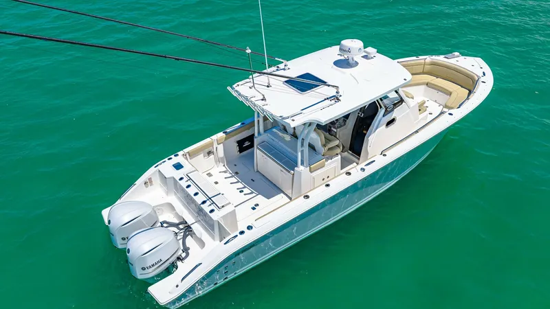 Slide: The Image of Aerial View of Pursuit 328 Deck This aerial shot captures the sleek design of the 2019 Pursuit 328, showcasing its spacious deck layout. The vessel features ample seating at the bow and a well-equipped helm under a protective hardtop. Twin outboard engines offer powerful performance, pe - 7095020