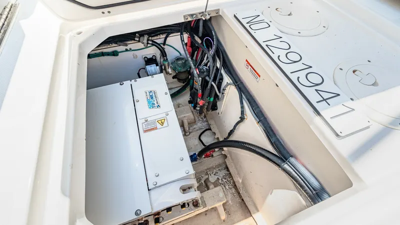 Slide: The Image of Engine Compartment Access Hatch This image showcases the engine compartment of the 2019 Pursuit 328 Orcabessa. The area is neatly organized with visible wiring and equipment, ensuring efficient access and maintenance. The compartment features a clean and well-maintained space, highlight - 7095049