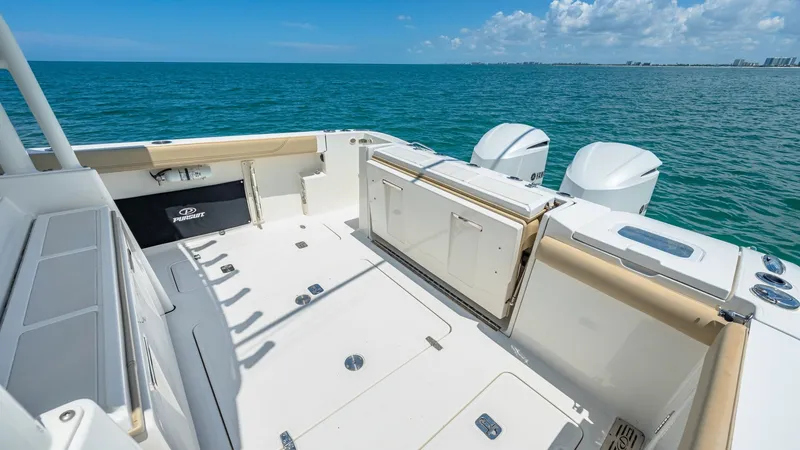 Slide: The Image of Spacious Aft Deck with Seating The aft deck of the 2019 Pursuit 328, Orcabessa, offers a generous space ideal for leisure and fishing activities. It features ample seating with plush, cushioned surfaces and convenient storage compartments. The twin outboard engines are seamlessly integ - 7095026